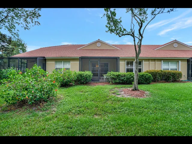 a view of a house with a yard and potted plants
