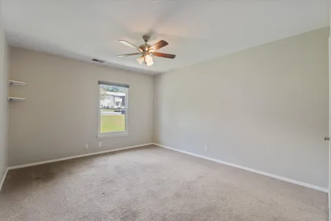 a view of an empty room and a ceiling fan