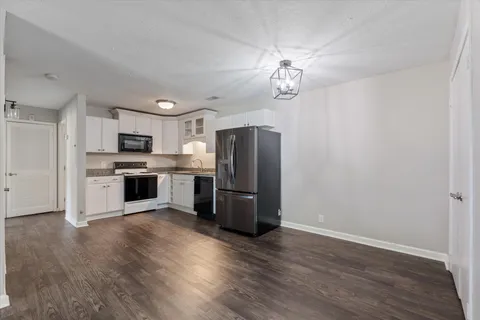 a kitchen with a refrigerator stove and wooden cabinets