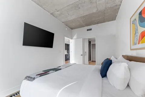 a bedroom with a bed and a flat screen tv