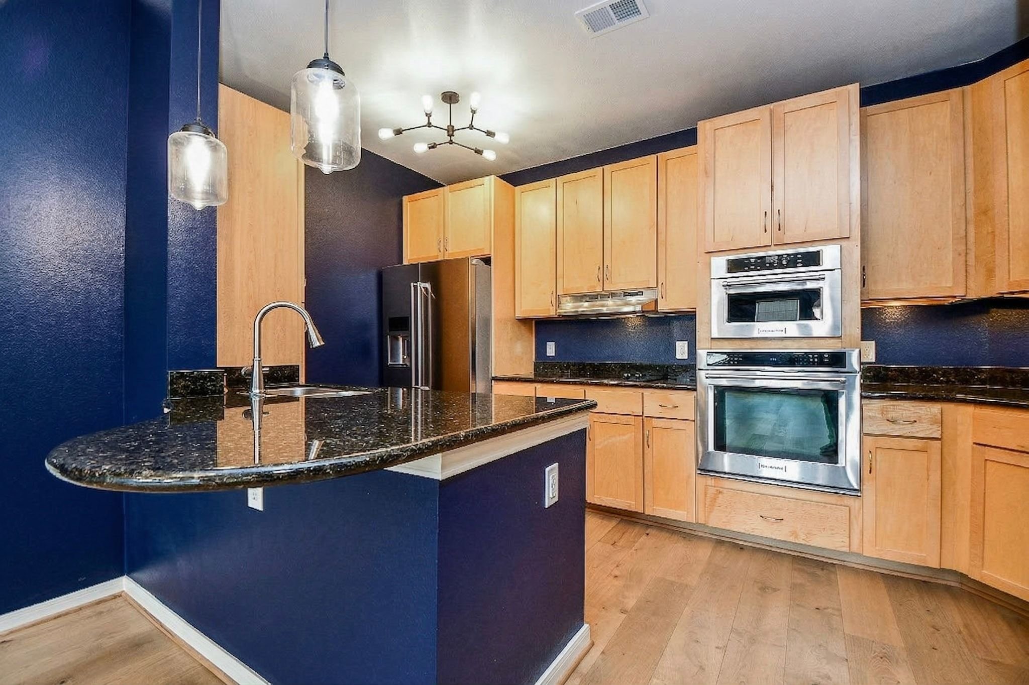 505 Jackson Hill Street, Unit 307 Houston, TX 77007 - Photo 6 of 30 a kitchen with kitchen island granite countertop a stove cabinets and microwave