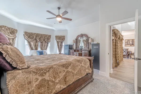 a bedroom with a large bed and a chandelier