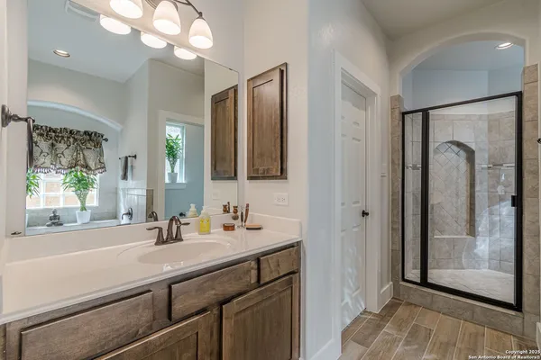 a bathroom with a sink a mirror a vanity and a bathtub