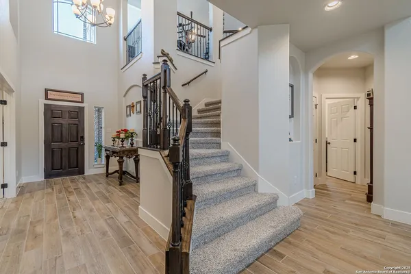 a view of a hallway with wooden floor and staircase