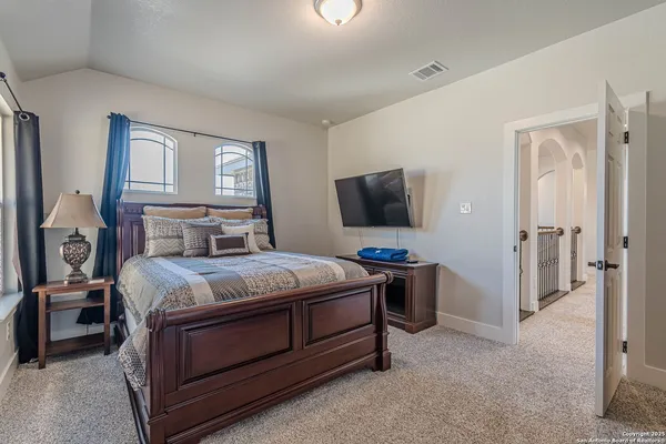 a bedroom with a bed and a flat tv screen on wall