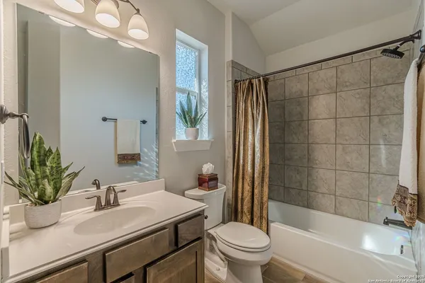 a bathroom with a sink a toilet a mirror and shower