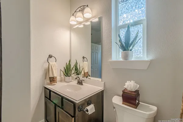 a bathroom with a sink and a mirror with toilet