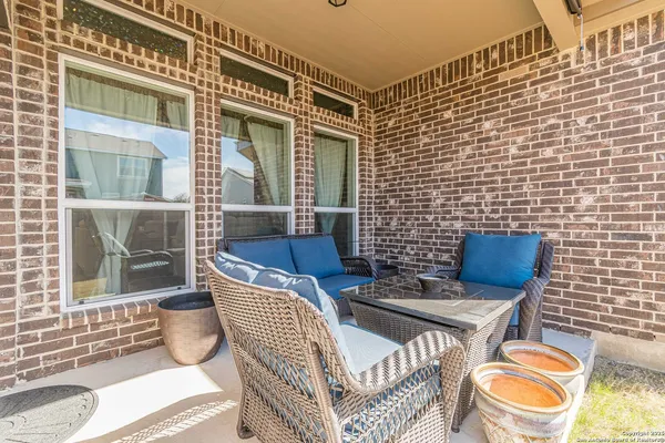 a view of a patio with couches chairs and wooden floor
