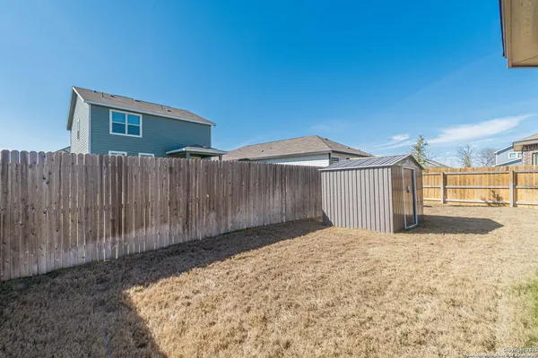 a view of backyard with wooden fence