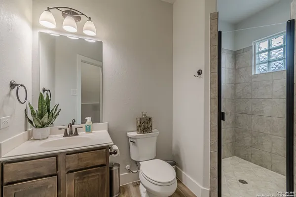 a bathroom with a sink a toilet and shower