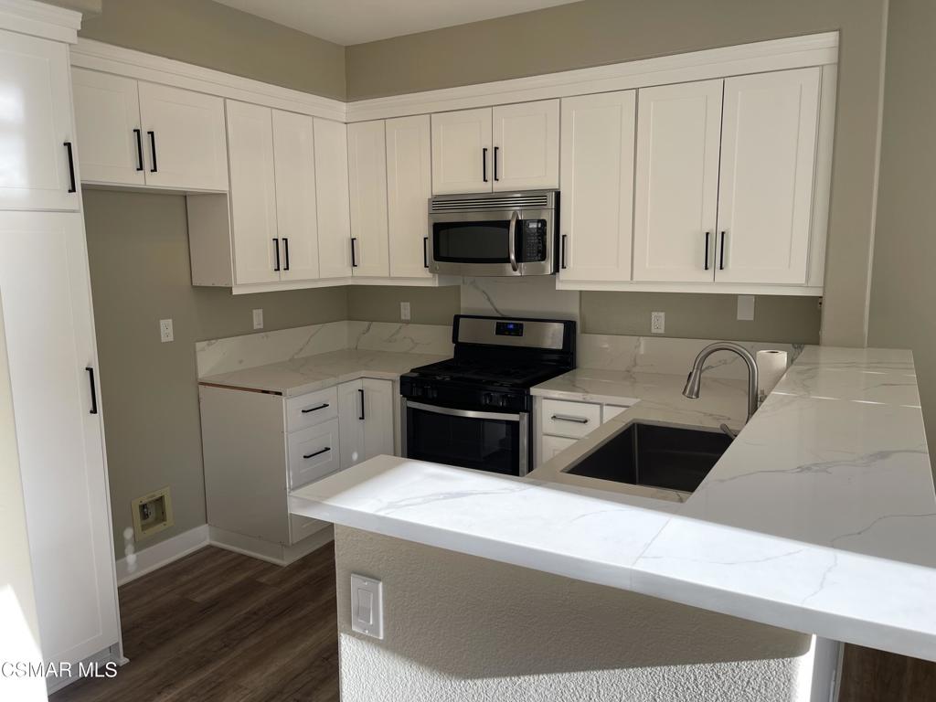 429 Dante Way Oak Park, CA 91377 - Photo 12 of 37 a kitchen with stainless steel appliances a stove a microwave a sink and cabinets