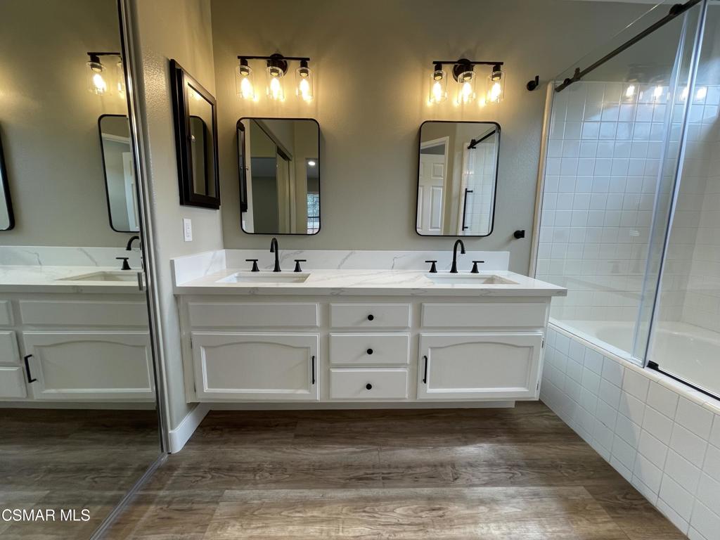 429 Dante Way Oak Park, CA 91377 - Photo 25 of 37 a bathroom with a double vanity sink a mirror and a bathtub