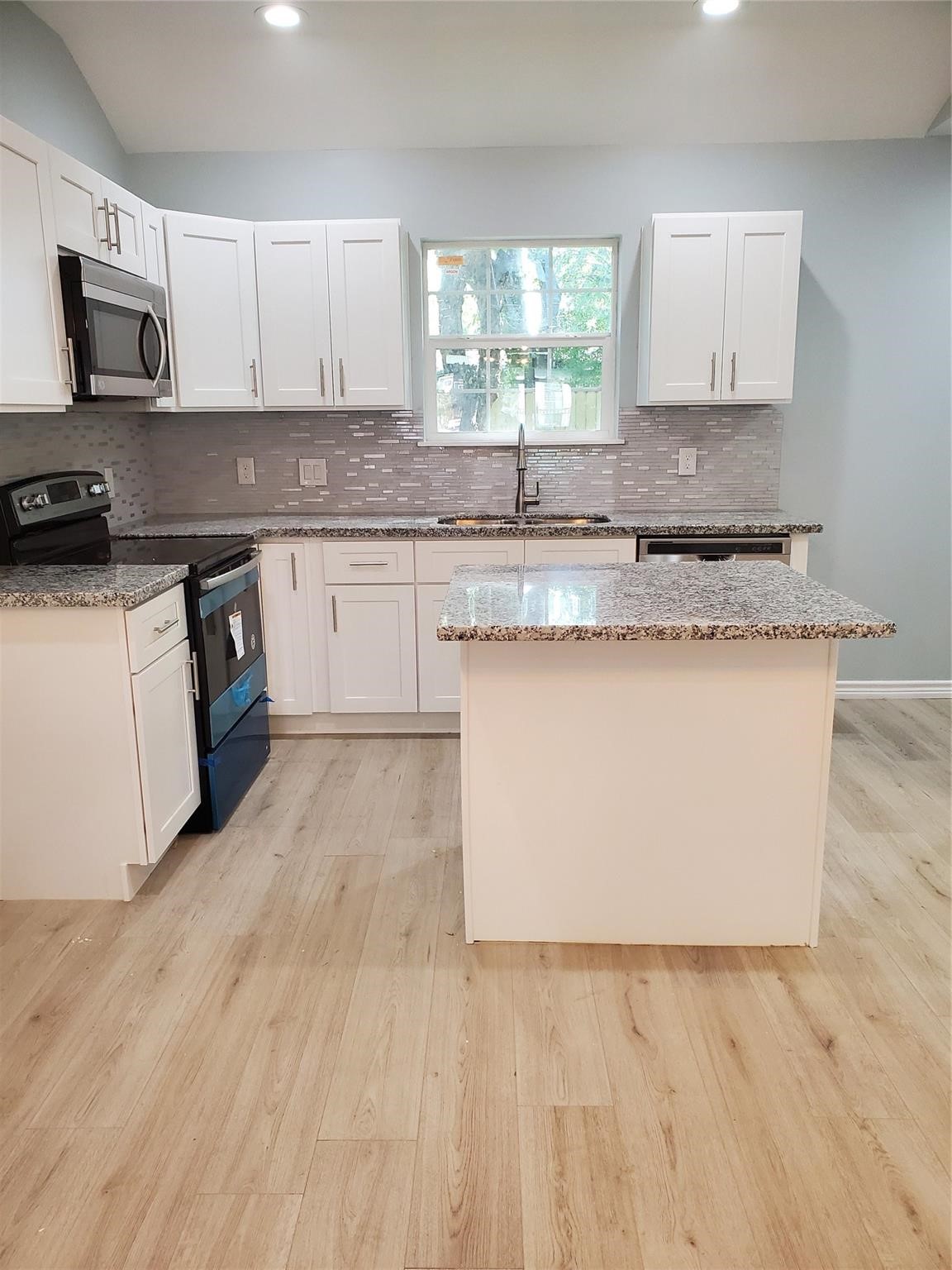6815 Sidney Street Houston, TX 77021 - Photo 4 of 14 a kitchen with granite countertop a stove top oven sink and cabinets