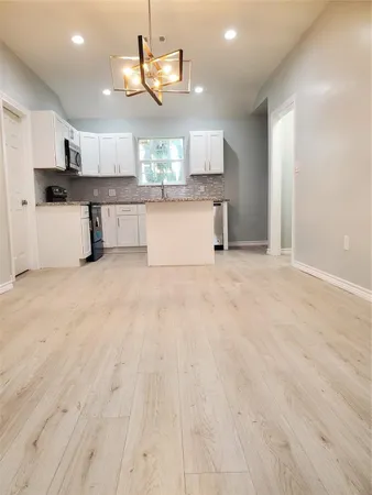 an empty room with closet and windows