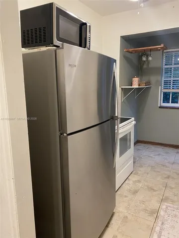 a kitchen with a refrigerator and a window