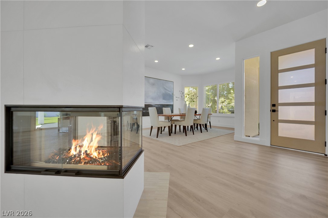 8981 Rivers Edge Drive Las Vegas, NV 89117 - Photo 15 of 69 A modern hearth creates a warm focal point, complementing light wood flooring and a luminous dining space.