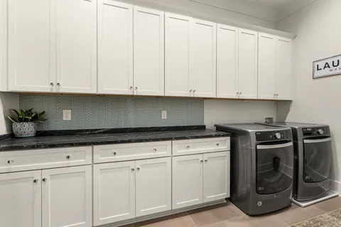 a en suite bathroom with a granite countertop double vanity sink and a mirror