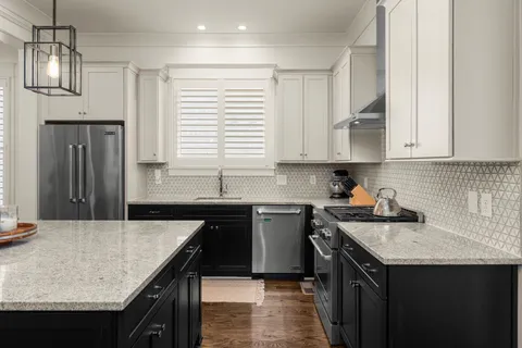 a kitchen with stainless steel appliances granite countertop a stove refrigerator and cabinets