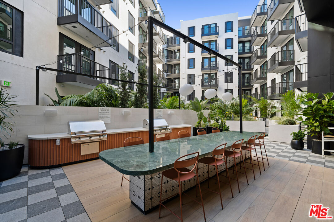 250 East Broadway, Unit 803 Long Beach, CA 90802 - Photo 16 of 44 a backyard of a house with barbeque oven table and chairs