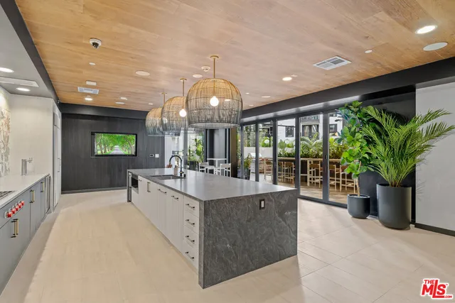 a large white kitchen with a large counter top and stainless steel appliances