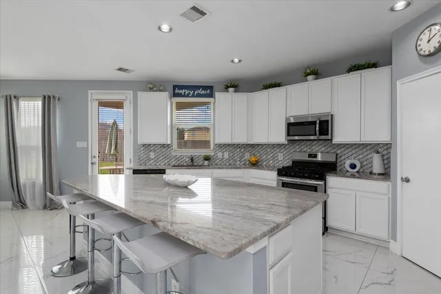 a kitchen with granite countertop a stove sink and cabinets