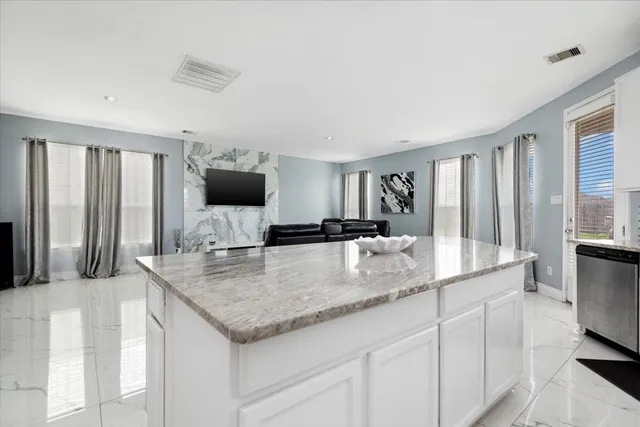 a kitchen with stainless steel appliances granite countertop a sink and a refrigerator