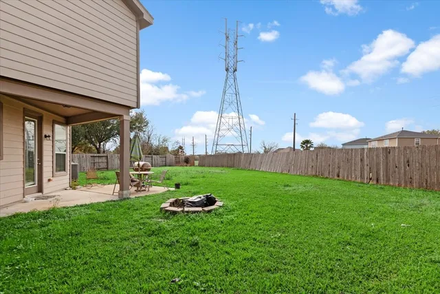 a view of a backyard with table and chairs and wooden fence