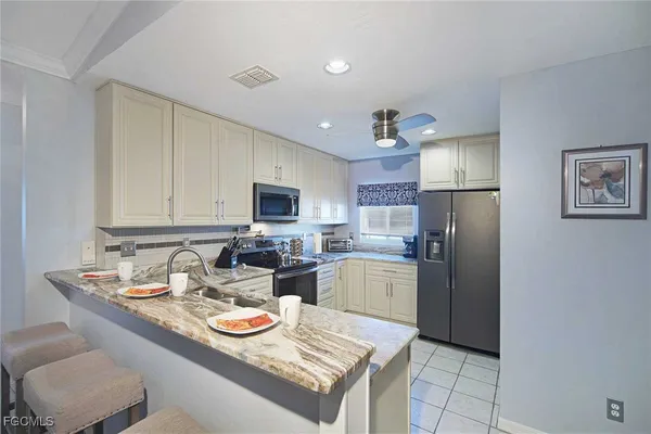 a kitchen with a refrigerator a stove and a dining table