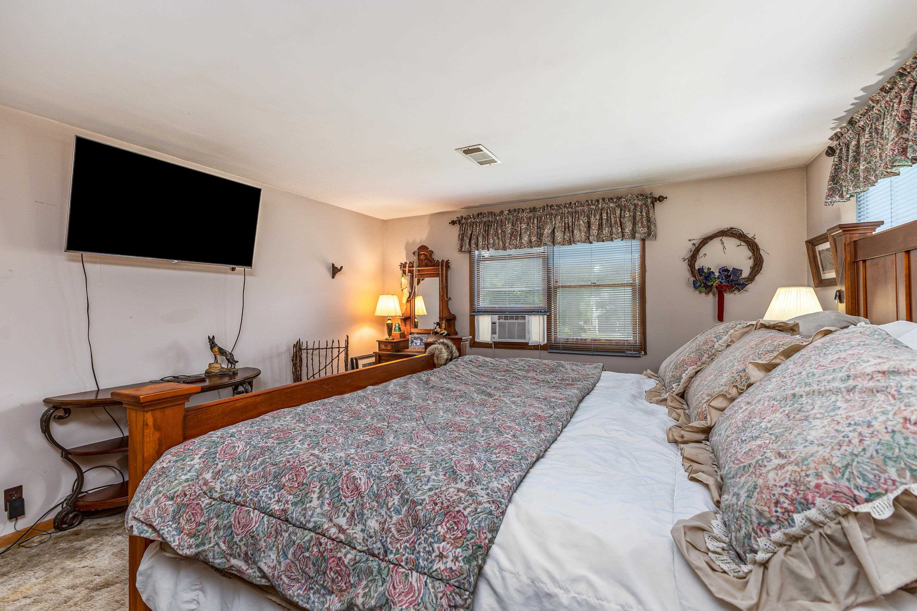 103 4th Street Galena, IL 61036 - Photo 15 of 64 a bedroom with a large bed and a flat tv screen on dresser