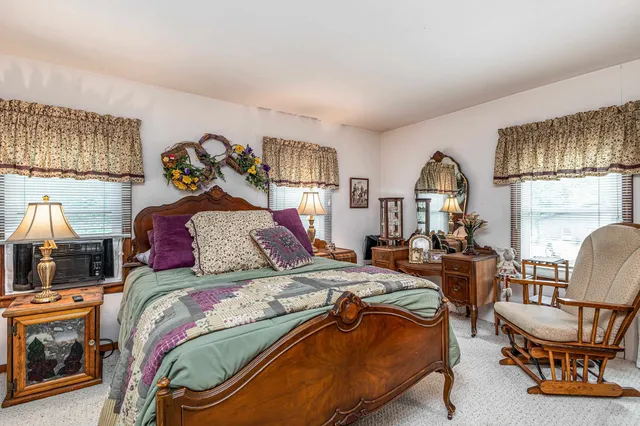 a spacious bedroom with a bed a couch and a window