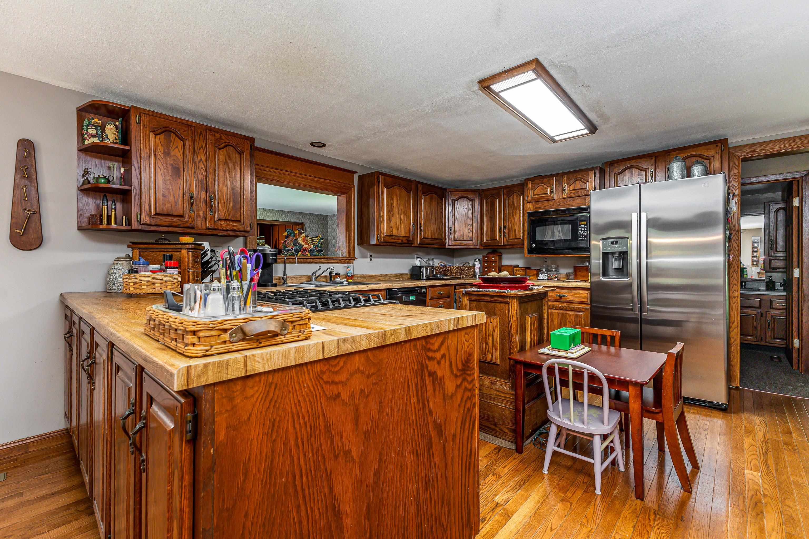 103 4th Street Galena, IL 61036 - Photo 31 of 64 a kitchen with stainless steel appliances kitchen island granite countertop a table chairs in it and wooden floors