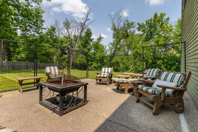 a view of swimming pool with lawn chairs and large trees