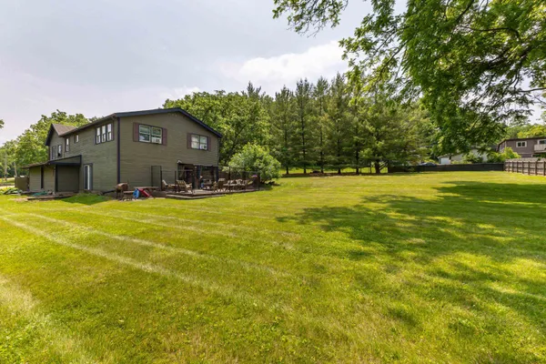 a house view with a wooden fence and trees