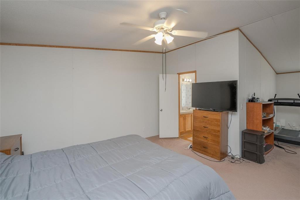 4260 Couch Road Ponder, TX 76259 - Photo 12 of 25 a bedroom with a bed and a chandelier