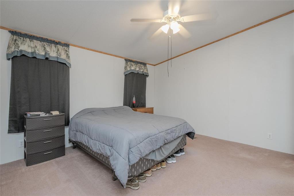 4260 Couch Road Ponder, TX 76259 - Photo 13 of 25 a bedroom with a bed and a chandelier