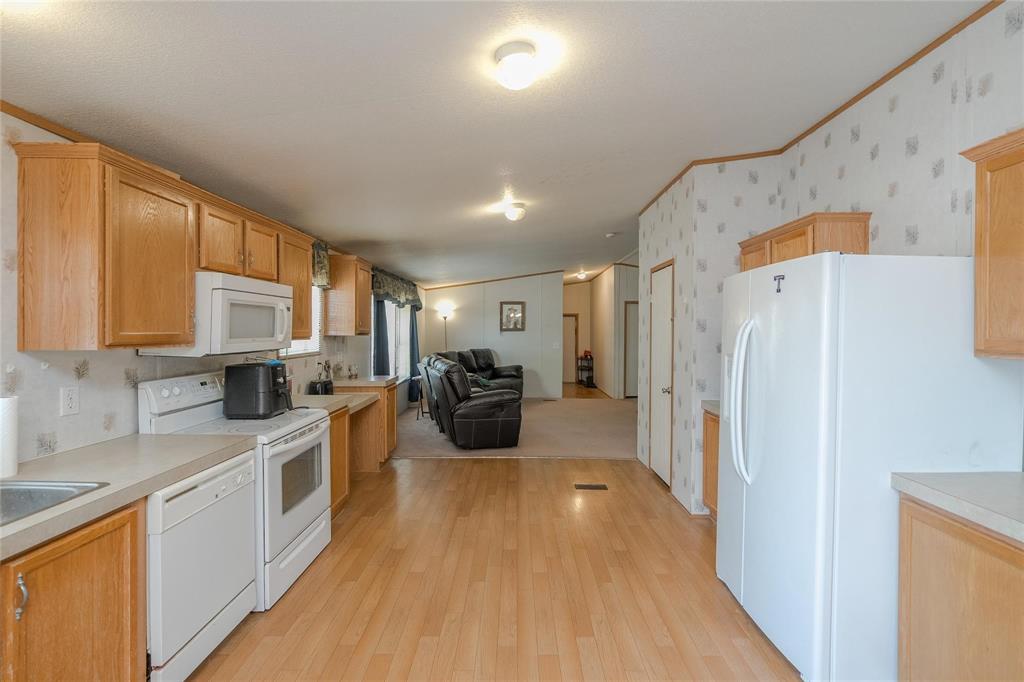 4260 Couch Road Ponder, TX 76259 - Photo 25 of 25 a kitchen with stainless steel appliances a refrigerator a sink dishwasher a oven with white cabinets and wooden floor