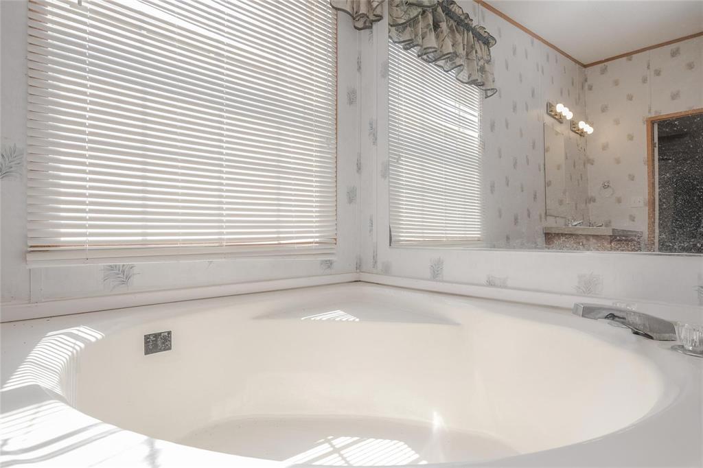 4260 Couch Road Ponder, TX 76259 - Photo 10 of 25 a white bath tub sitting in a bathroom next to a window