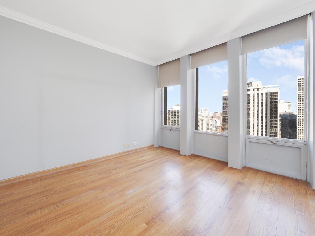 100 East Walton Street, Unit 27B Chicago, IL 60611 - Photo 11 of 18 wooden floor in an empty room with a window