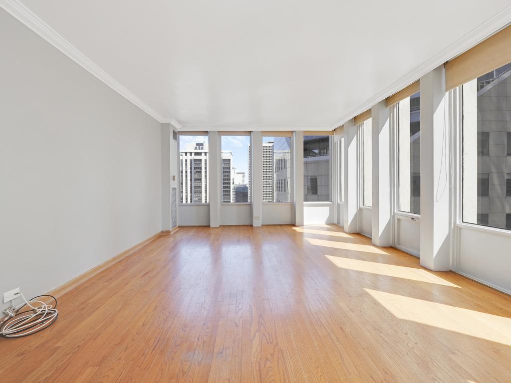 100 East Walton Street, Unit 27B Chicago, IL 60611 - Photo 12 of 18 a view of an empty room with wooden floor and a window