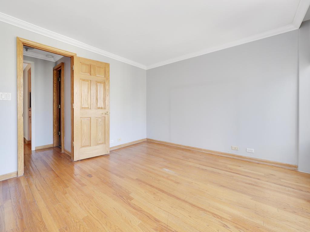 100 East Walton Street, Unit 27B Chicago, IL 60611 - Photo 14 of 18 a view of an empty room with wooden floor and a window
