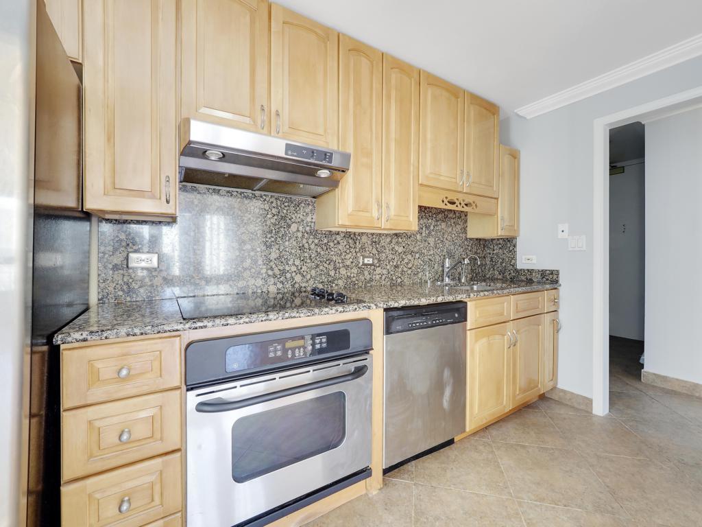 100 East Walton Street, Unit 27B Chicago, IL 60611 - Photo 8 of 18 a kitchen with granite countertop cabinets stainless steel appliances and a counter space