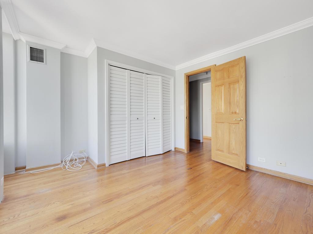 100 East Walton Street, Unit 27B Chicago, IL 60611 - Photo 9 of 18 an empty room with wooden floor and closet