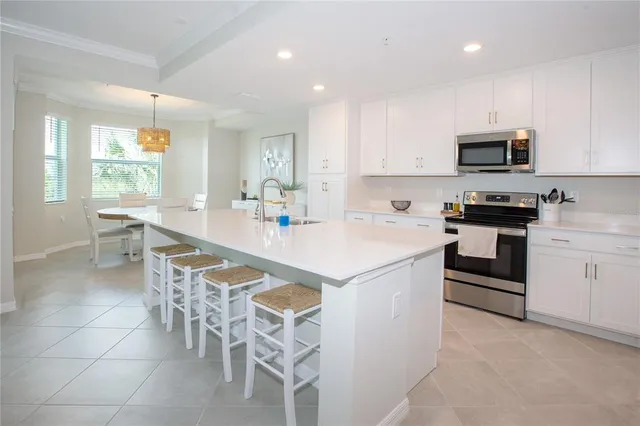 a kitchen with stainless steel appliances a stove a sink a microwave a refrigerator and cabinets