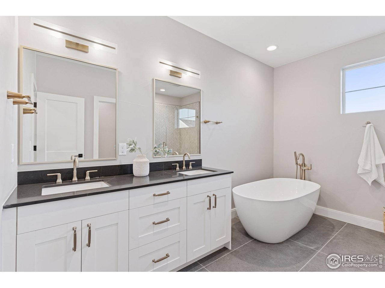 927 William Way Berthoud, CO 80513 - Photo 15 of 28 a spacious bathroom with a double vanity sink and a mirror