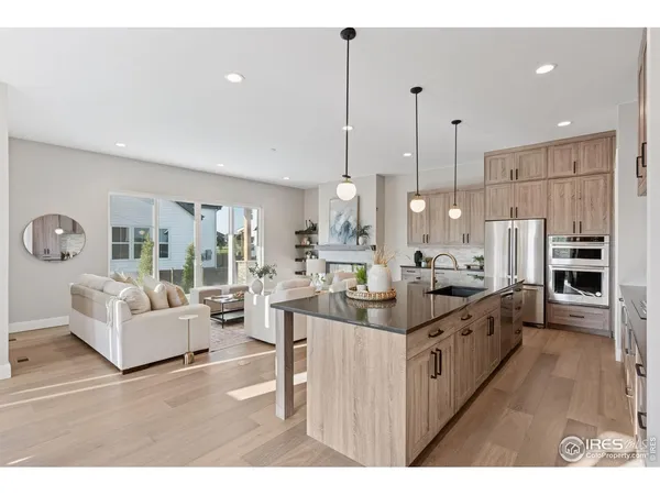 a large kitchen with kitchen island a large counter top a sink a stove and a refrigerator