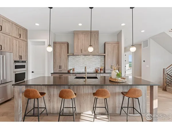 a kitchen with stainless steel appliances kitchen island a chandelier and refrigerator