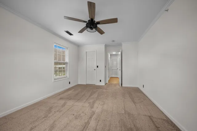 a view of empty room with a ceiling fan and window