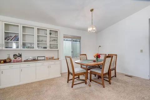 a dining room with a wooden table and chairs