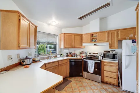 a kitchen with a sink a stove a refrigerator and cabinets