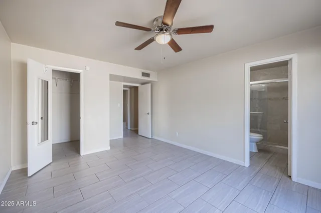 a view of a livingroom with a ceiling fan and a bathroom